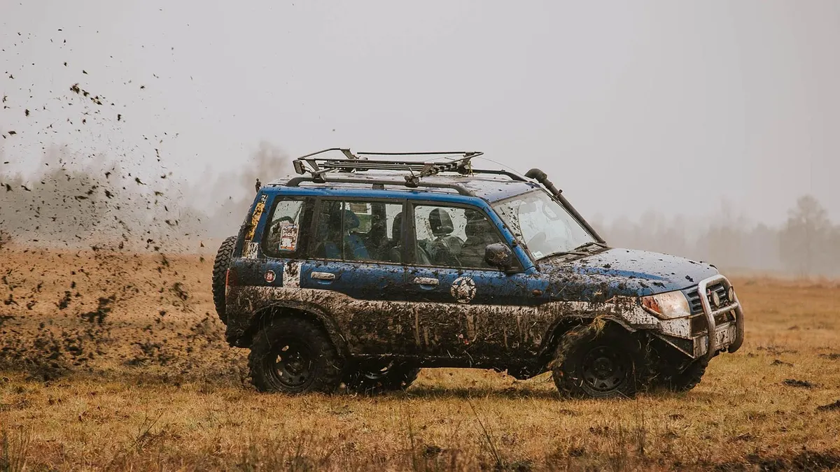 Jipe off-road sujo de lama em campo aberto