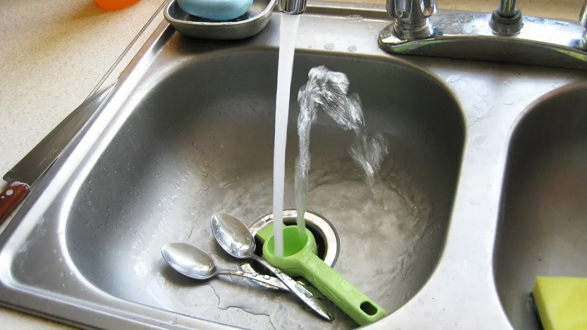 Pia de cozinha de inox com água corrente