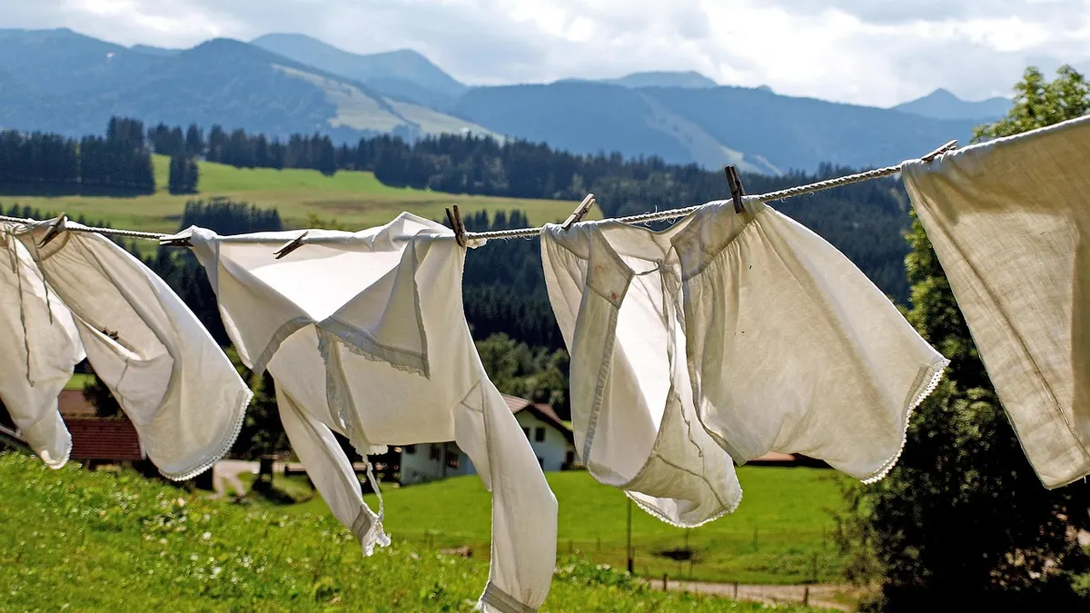 Roupas brancas penduradas em varal sobre gramado
