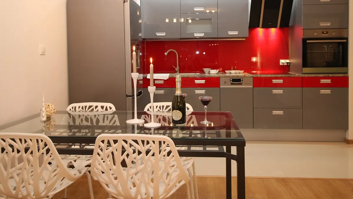 Cozinha moderna com armários cinza e revestimento vermelho